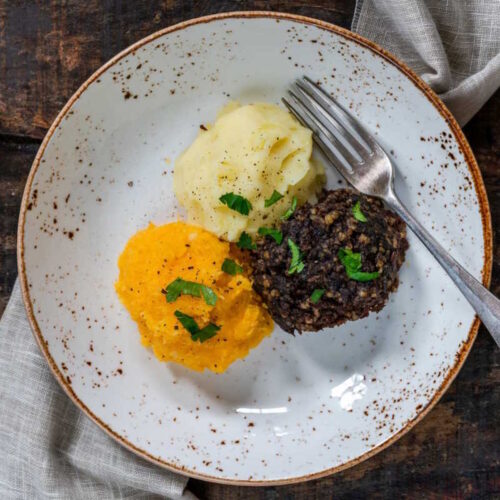 Oven-baked plant-based haggis, with a side of warm neeps and creamy mashed potatoes.