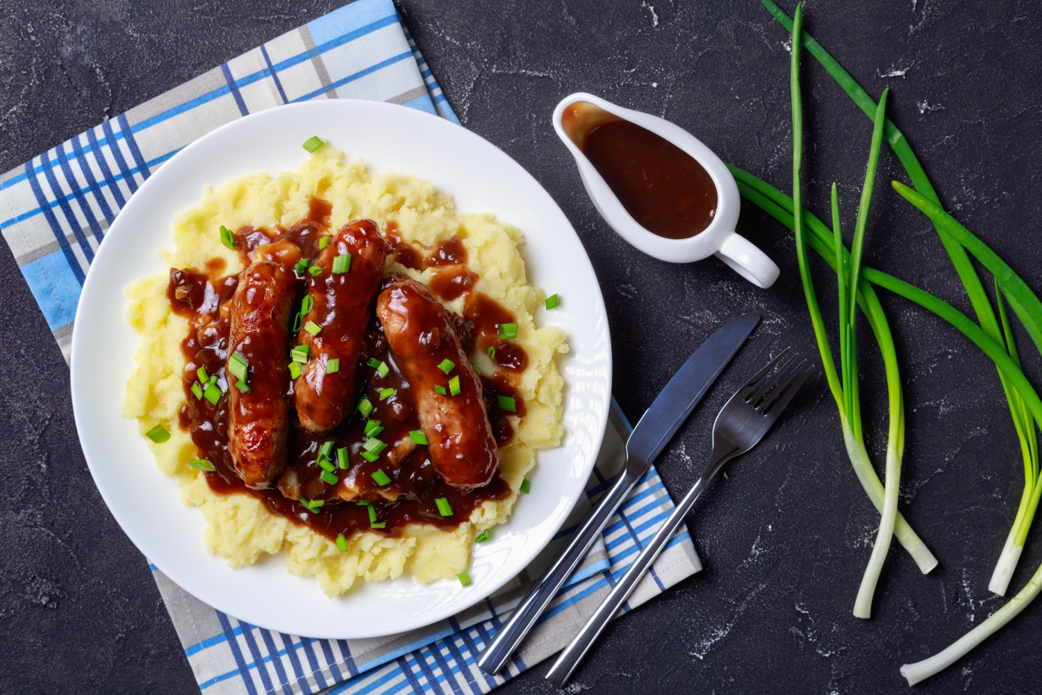 Vegan sausages and mashed potato covered in an onion gravy.