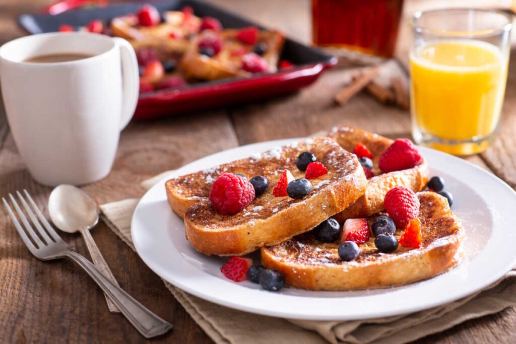 Gooey French toast covered in berries, syrup and icing sugar. Served with coffee and orange juice.