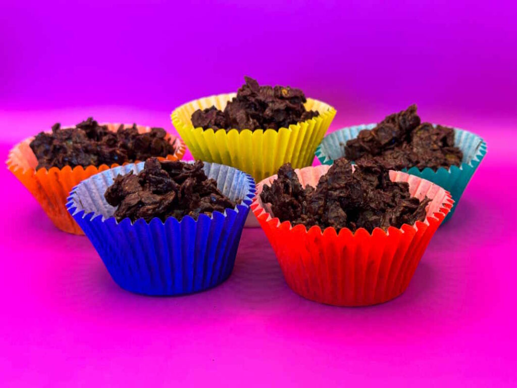 A bunch of colourful cupcake cups full of crispy chocolate and golden syrup covered cornflakes.