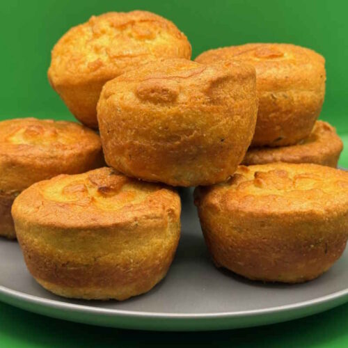 A plate of golden and crisp vegan Yorkshire puddings.