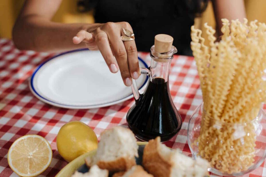 Woman reaching for traditional balsamic vinegar.