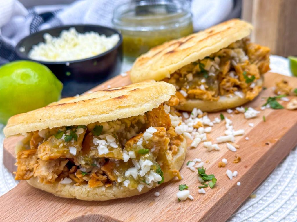 Vegan Arepas with Mexican Style Shredded Plant Chicken served with Salsa Verde, Lime Wedges and Vegan Cheese